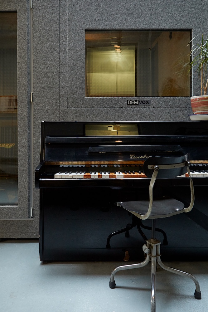 piano and chair outside a vocal booth