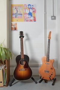 two guitars in stands in singing school