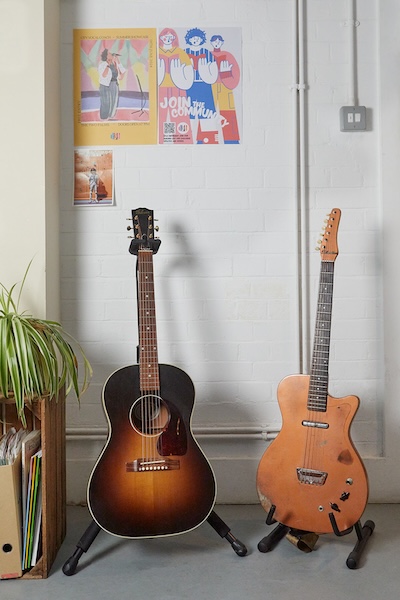 two guitars in stands in singing school