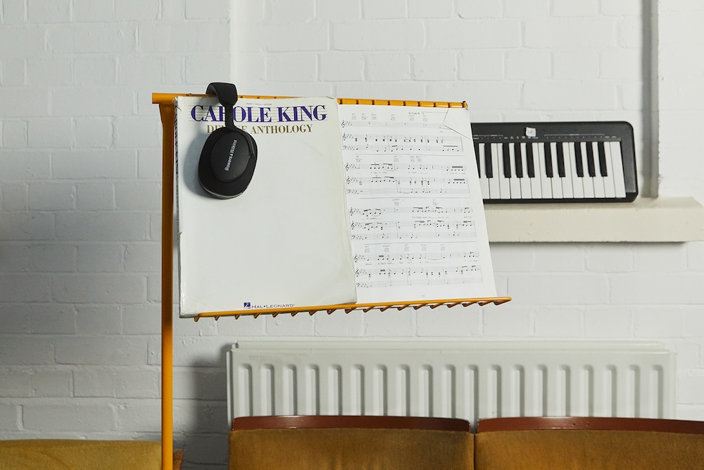 yellow music stand with Carole King music and headphones